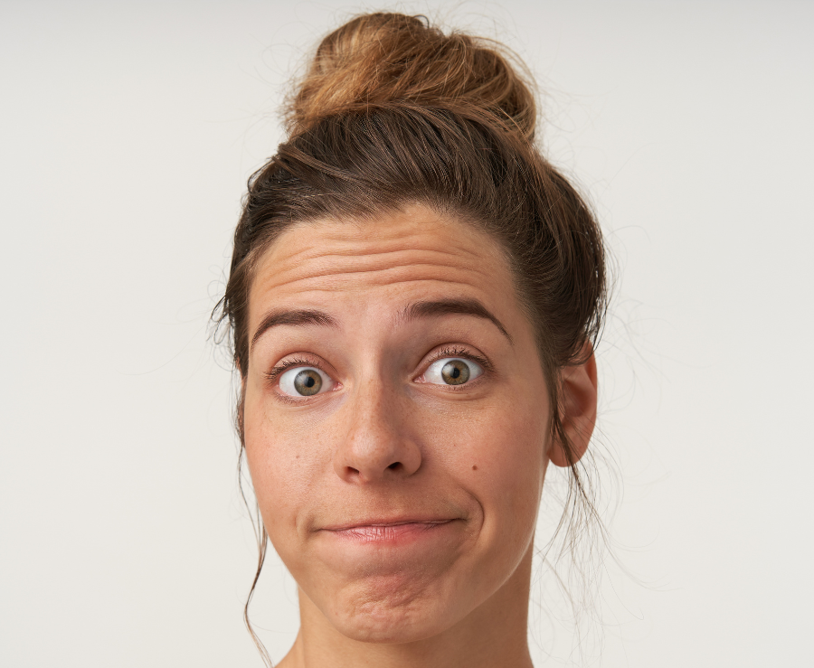 close-up-attractive-young-woman-posing-with-bewildered-face-wearing-bun-hairstyle-no-make-up-wrinkling-forehead-pursing-lips